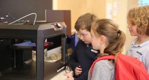 Students looking at a 3D printer